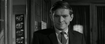 Movie still from “Billy Liar” (1963), directed by John Schlesinger – Black and white photograph of a man in a suit and tie; Close Up shot, Low angle