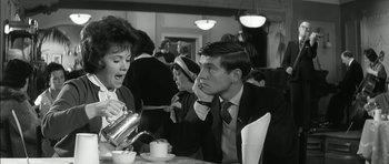 Movie still from “Billy Liar” (1963), directed by John Schlesinger – A man and a woman sitting at a table with a tea pot in front of them; Medium shot, Over the shoulder angle