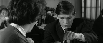 Movie still from “Billy Liar” (1963), directed by John Schlesinger – A man in a suit and tie looking down at a woman; Close Up shot, Over the shoulder angle