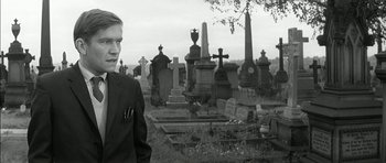 Movie still from “Billy Liar” (1963), directed by John Schlesinger – A young man standing in front of a graveyard; Medium shot, Over the shoulder angle