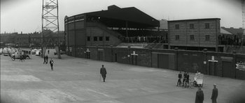 Movie still from “Billy Liar” (1963), directed by John Schlesinger – A man walking down a street with a cane; Extreme Wide shot, High angle