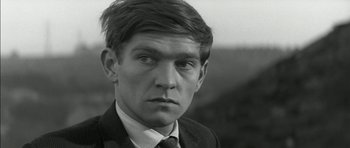 Movie still from “Billy Liar” (1963), directed by John Schlesinger – Black and white photograph of a man in a suit and tie; Close Up shot, Over the shoulder angle