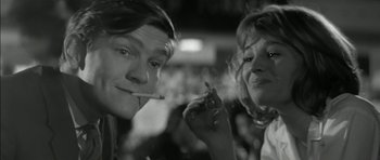 Movie still from “Billy Liar” (1963), directed by John Schlesinger – A couple of people that are standing up smoking; Close Up shot, Low angle