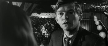 Movie still from “Billy Liar” (1963), directed by John Schlesinger – Black and white photograph of a man in a suit and tie; Close Up shot, Over the shoulder angle