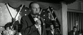 Movie still from “Billy Liar” (1963), directed by John Schlesinger – A black and white photo of a man singing; Medium shot, Low angle