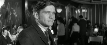 Movie still from “Billy Liar” (1963), directed by John Schlesinger – Black and white photograph of a man wearing a suit and tie; Close Up shot, Low angle