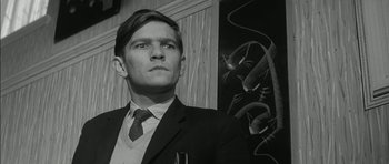 Movie still from “Billy Liar” (1963), directed by John Schlesinger – Black and white photograph of a man wearing a suit and tie; Close Up shot, Low angle