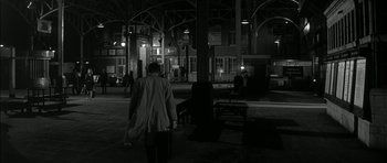 Movie still from “Billy Liar” (1963), directed by John Schlesinger – A person walking down a street at night; Wide shot, High angle