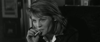 Movie still from “Billy Liar” (1963), directed by John Schlesinger – A black and white photo of a woman smoking a cigarette; Close Up shot, High angle
