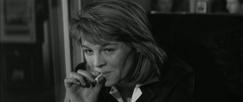 Movie still from “Billy Liar” (1963), directed by John Schlesinger – A black and white photo of a woman smoking a cigarette; Close Up shot, High angle