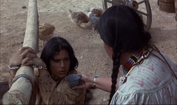 Movie still from “Billy Two Hats” (1974), directed by Ted Kotcheff – A woman is holding a bowl and a woman is holding a cup; Medium shot, Over the shoulder angle