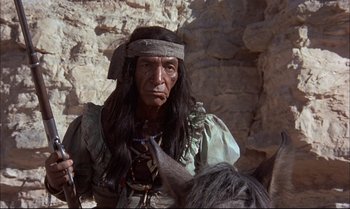 Movie still from “Billy Two Hats” (1974), directed by Ted Kotcheff – A man in a native american costume on a horse; Medium shot, Low angle