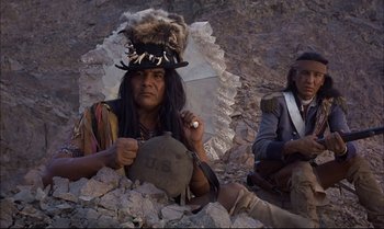 Movie still from “Billy Two Hats” (1974), directed by Ted Kotcheff – Two native americans sitting on the ground with a drum; Medium shot, Low angle