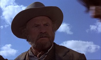 Movie still from “Billy Two Hats” (1974), directed by Ted Kotcheff – An old man with a beard wearing a cowboy hat; Close Up shot, Low angle