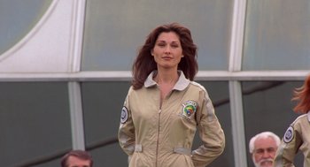 Movie still from “Bio-Dome” (1996), directed by Jason Bloom – A woman in a flight suit standing in front of a building; Medium shot, Low angle