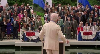 Movie still from “Bio-Dome” (1996), directed by Jason Bloom – A crowd of people watching a man in a white suit; Wide shot, High angle
