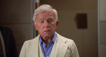 Movie still from “Bio-Dome” (1996), directed by Jason Bloom – An older man in a white striped jacket; Close Up shot, Low angle