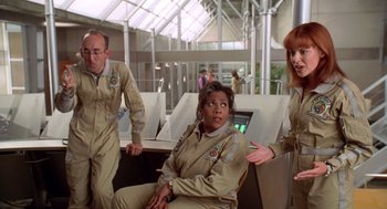 Movie still from “Bio-Dome” (1996), directed by Jason Bloom – A group of people standing in a room; Medium shot, Over the shoulder angle