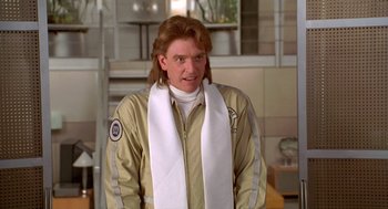 Movie still from “Bio-Dome” (1996), directed by Jason Bloom – A man with long red hair wearing a white scarf; Close Up shot, Low angle