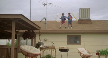 Movie still from “Bio-Dome” (1996), directed by Jason Bloom – Two children standing on the roof of a house; Wide shot, Low angle