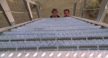 Movie still from “Bio-Dome” (1996), directed by Jason Bloom – Two men are standing on a metal walkway; Wide shot, Low angle