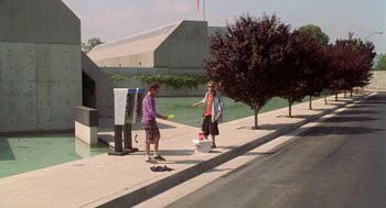 Movie still from “Bio-Dome” (1996), directed by Jason Bloom – Two people standing on the side of the street; Wide shot, Low angle