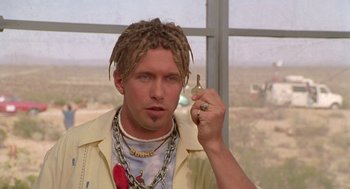 Movie still from “Bio-Dome” (1996), directed by Jason Bloom – A man with dreadlocks holding a key in his hand; Close Up shot, Low angle