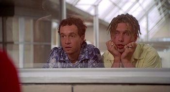 Movie still from “Bio-Dome” (1996), directed by Jason Bloom – Two men sitting next to each other in front of a window; Close Up shot, Low angle