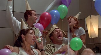 Movie still from “Bio-Dome” (1996), directed by Jason Bloom – A group of people wearing party hats and holding balloons; Medium shot, Overhead angle