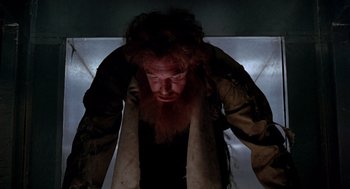 Movie still from “Bio-Dome” (1996), directed by Jason Bloom – A man with long red hair and a long beard; Medium shot, Low angle