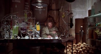 Movie still from “Bio-Dome” (1996), directed by Jason Bloom – A person sitting at a table with some food; Medium shot, Low angle