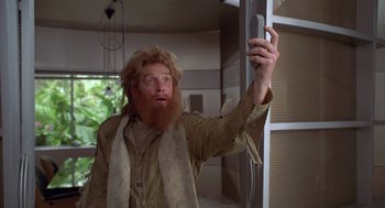 Movie still from “Bio-Dome” (1996), directed by Jason Bloom – A man with long hair and a red beard is taking a selfie; Medium shot, Low angle
