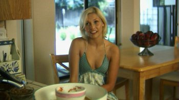 Movie still from “Birdemic: Shock and Terror” (2010), directed by James Nguyen – A beautiful young lady sitting at a table with a cake in front of her; Close Up shot, High angle