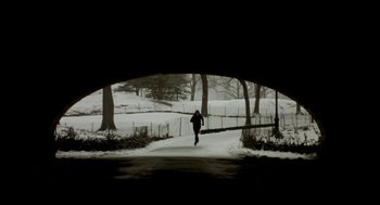 Movie still from “Birth” (2004), directed by Jonathan Glazer – A person is running in the snow under a bridge; Extreme Wide shot, Low angle