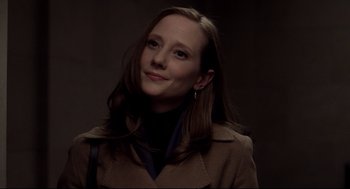 Movie still from “Birth” (2004), directed by Jonathan Glazer – A woman in a brown coat is smiling for the camera; Close Up shot, Over the shoulder angle