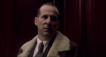 Movie still from “Birth” (2004), directed by Jonathan Glazer – A man in a suit and tie wearing a coat and tie; Close Up shot, Low angle