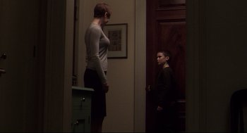 Movie still from “Birth” (2004), directed by Jonathan Glazer – A woman standing next to a young boy in front of a door; Wide shot, Over the shoulder angle