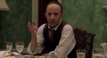 Movie still from “Birth” (2004), directed by Jonathan Glazer – A man sitting at a table with a glass of wine; Close Up shot, Over the shoulder angle