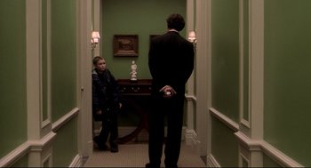 Movie still from “Birth” (2004), directed by Jonathan Glazer – A man and a boy are standing in a hallway; Medium shot, Over the shoulder angle