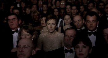 Movie still from “Birth” (2004), directed by Jonathan Glazer – A crowd of people standing in a room; Medium shot, High angle