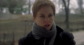 Movie still from “Birth” (2004), directed by Jonathan Glazer – A person wearing a jacket and a scarf; Close Up shot, Over the shoulder angle
