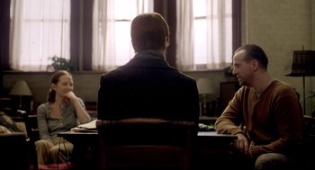 Movie still from “Birth” (2004), directed by Jonathan Glazer – Three people sitting at a table in front of a window; Medium shot, Over the shoulder angle