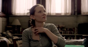 Movie still from “Birth” (2004), directed by Jonathan Glazer – A woman sitting at a table with her hand under her chin; Close Up shot, Over the shoulder angle