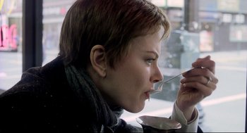 Movie still from “Birth” (2004), directed by Jonathan Glazer – A woman is eating something while sitting at a table; Close Up shot, Over the shoulder angle