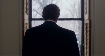 Movie still from “Birth” (2004), directed by Jonathan Glazer – A man in a suit looking out of a window; Medium shot, Over the shoulder angle