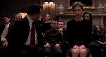 Movie still from “Birth” (2004), directed by Jonathan Glazer – A group of people sitting in a living room together; Medium shot, Over the shoulder angle