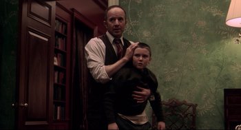 Movie still from “Birth” (2004), directed by Jonathan Glazer – A man and a boy are standing in front of a wall; Medium shot, Over the shoulder angle
