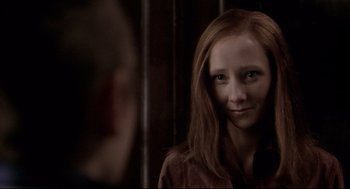 Movie still from “Birth” (2004), directed by Jonathan Glazer – A woman with long red hair is looking at the camera; Close Up shot, Over the shoulder angle