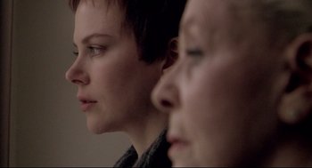 Movie still from “Birth” (2004), directed by Jonathan Glazer – Two women looking into the distance with their eyes wide open; Close Up shot, Over the shoulder angle