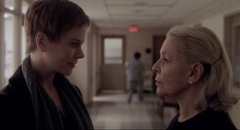 Movie still from “Birth” (2004), directed by Jonathan Glazer – Two women standing in a hallway talking to each other; Close Up shot, Over the shoulder angle
